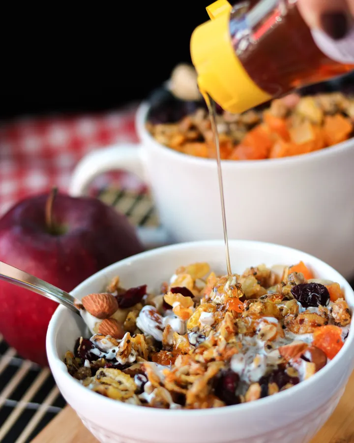 Mel caindo sobre granola com iogurte