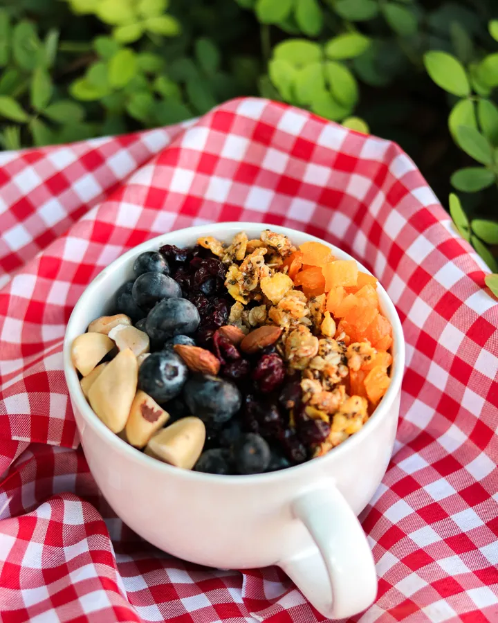 Xícara com granola, mirtilos e castanhas